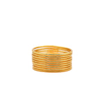 Pulseras delgadas en tono dorado apiladas sobre fondo blanco.
