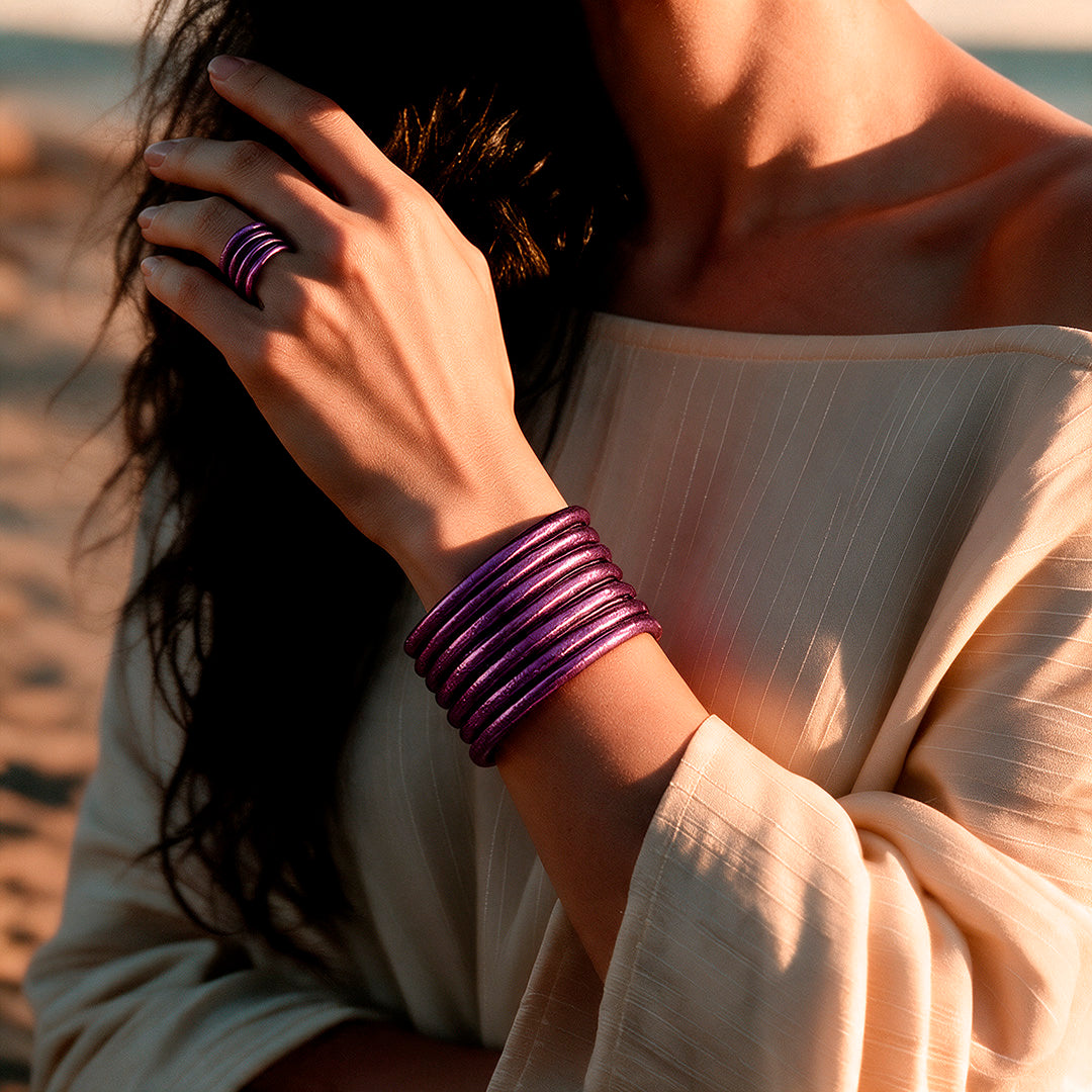 Muñeca con pulseras moradas.