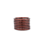 Pulseras en tonos cobre y oscuro apiladas sobre fondo blanco.