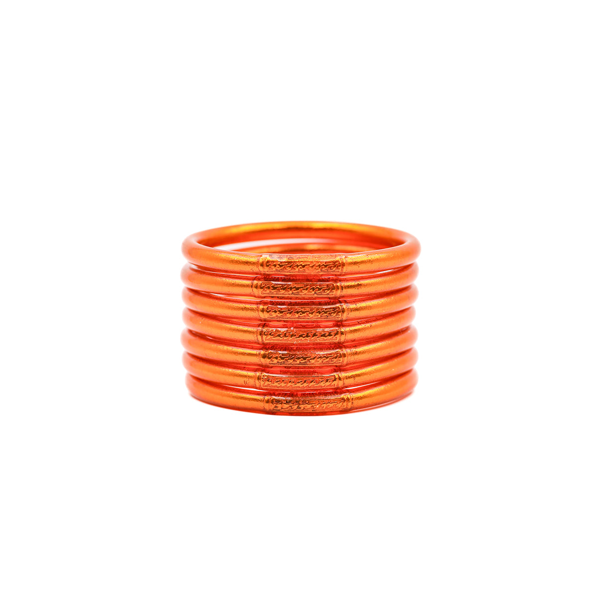 Pila de pulseras lisas naranjas sobre fondo blanco.