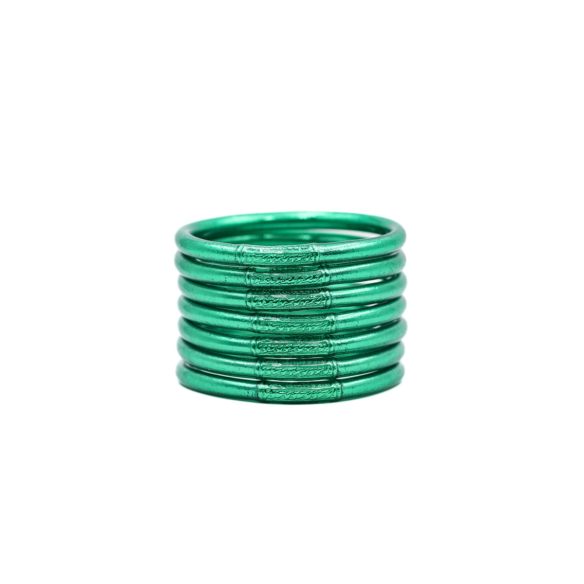 Pila de pulseras lisas verdes sobre fondo blanco.