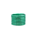 Pila de pulseras lisas verdes sobre fondo blanco.