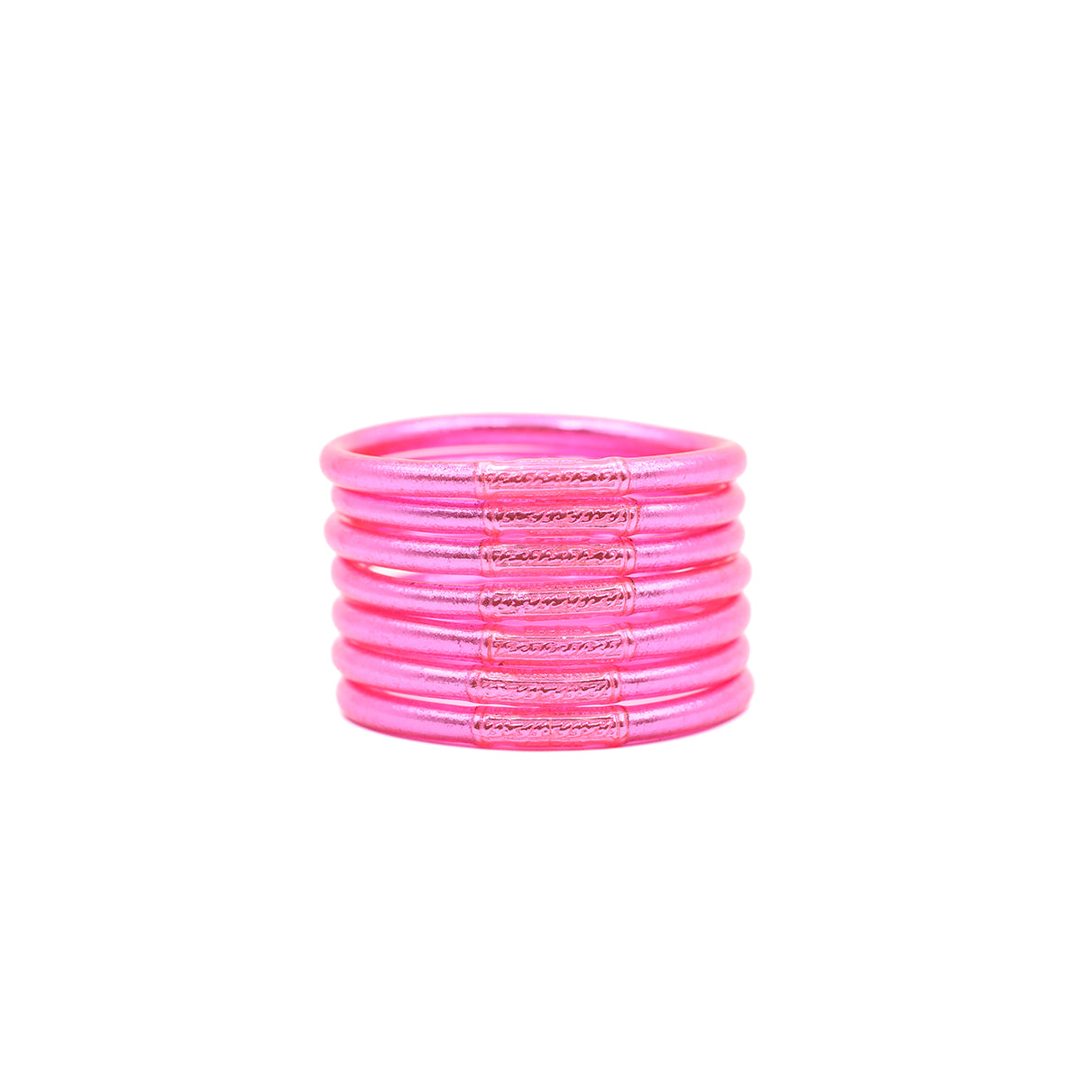 Pulseras rosas con detalles brillantes apiladas sobre fondo blanco.