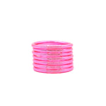 Pulseras rosas con detalles brillantes apiladas sobre fondo blanco.