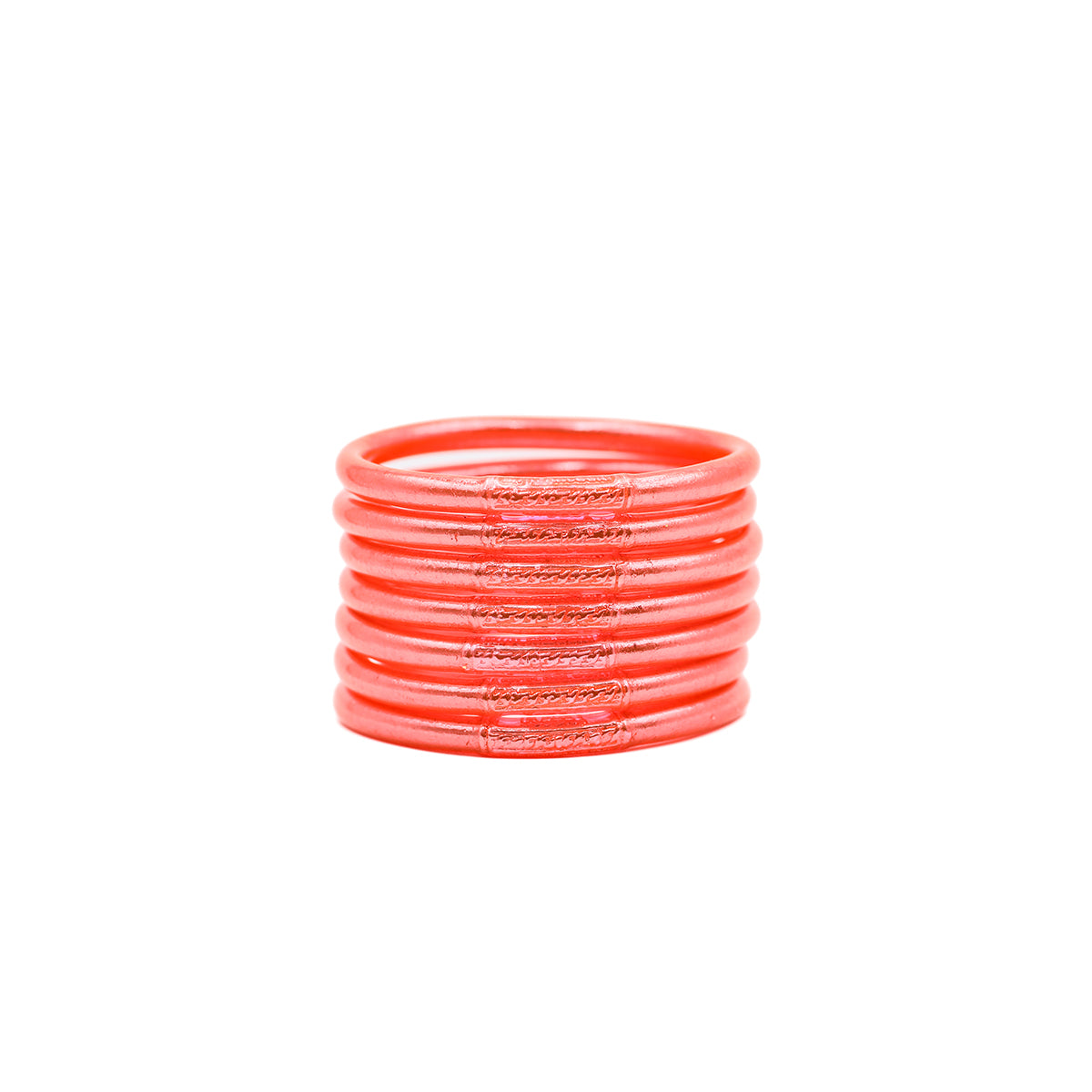 Pulseras naranjas con detalles brillantes apiladas sobre fondo blanco.