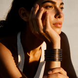 Muñeca con pulseras café oscuro.