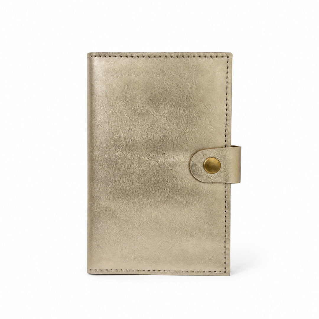Interior de cartera MANIKĀ de piel vacuna metalizada dorada, con ranuras para tarjetas y la frase "la gratitud es la semilla de la abundancia" grabada