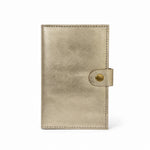 Interior de cartera MANIKĀ de piel vacuna metalizada dorada, con ranuras para tarjetas y la frase "la gratitud es la semilla de la abundancia" grabada